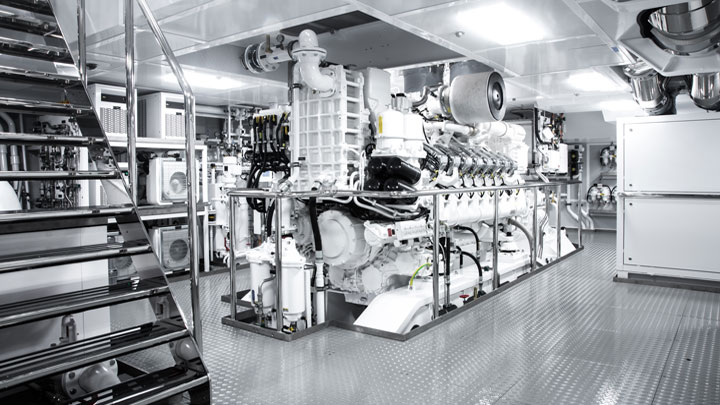 A superyacht engine room with twin diesel engines and stainless pipework